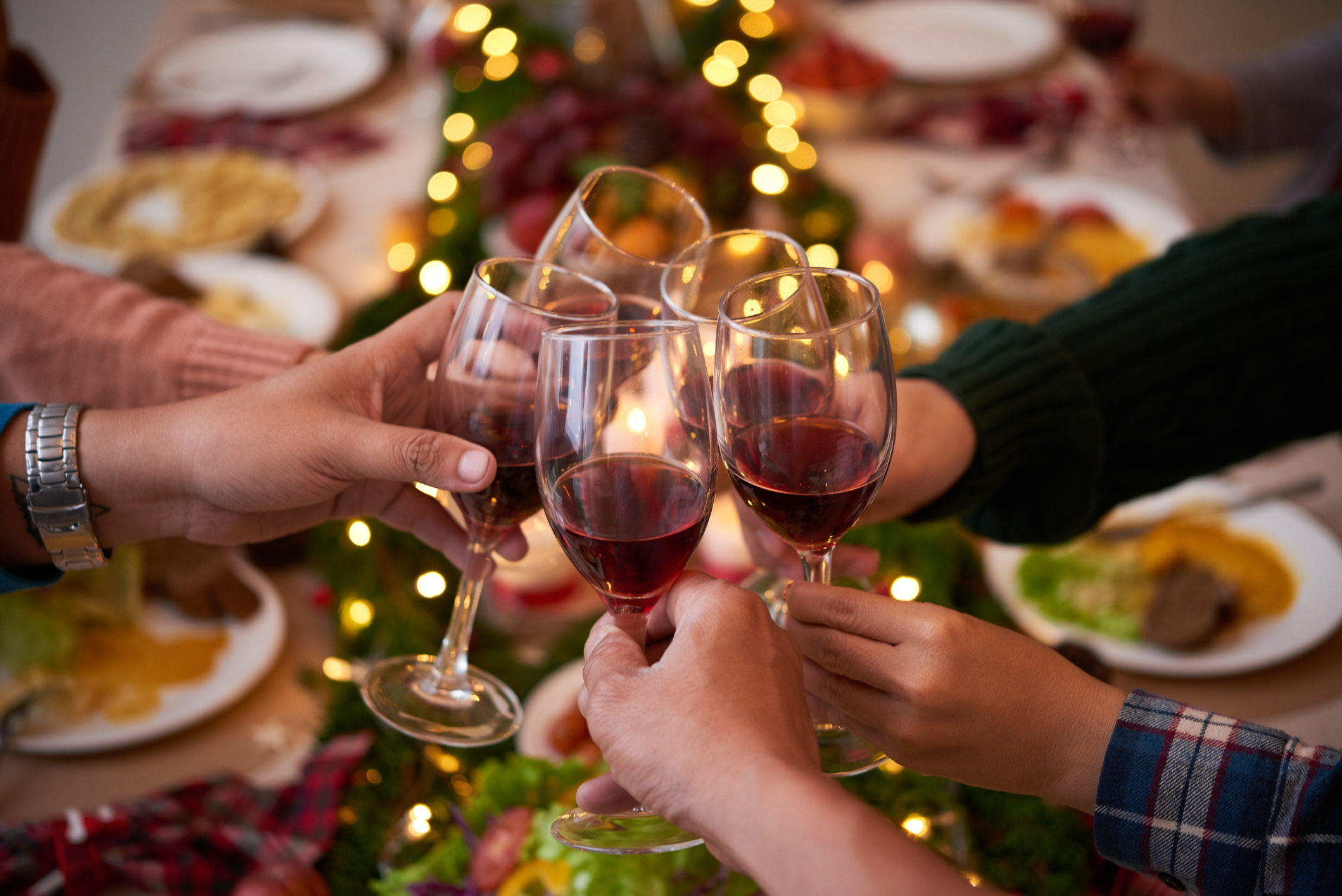 Toasting for Christmas Four people putting their glasses of red wine together in a toast.